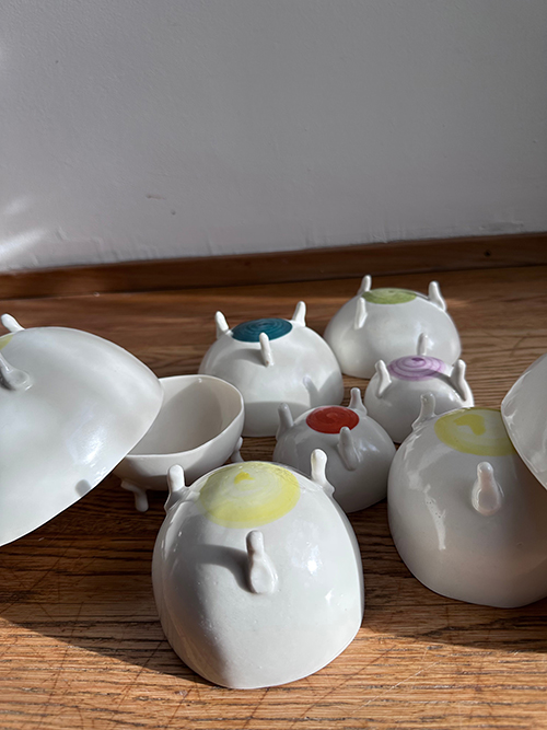 Fertigglasierte Porzellanschalen unterschiedlicher Größe mit unterschiedlich farbigen Punkten auf der Unterseite