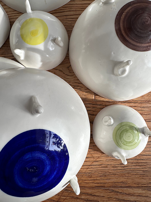 Fertigglasierte Porzellanschalen unterschiedlicher Größe mit unterschiedlich farbigen Punkten auf der Unterseite