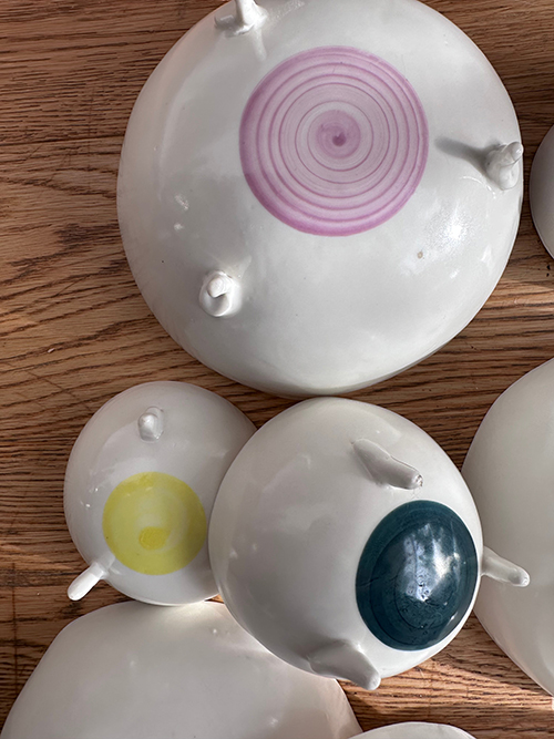 Fertigglasierte Porzellanschalen unterschiedlicher Größe mit unterschiedlich farbigen Punkten auf der Unterseite